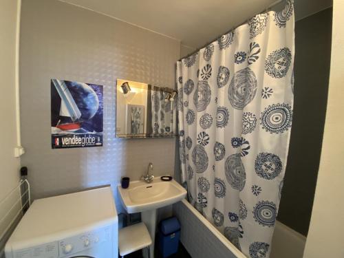 une salle de bain avec un lavabo et un rideau de douche dans l'établissement Appartement vue mer Chateau Olonne, à Château-dʼOlonne