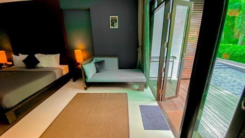a bedroom with a bed and a chair and a window at The Bihai Hua Hin in Hua Hin