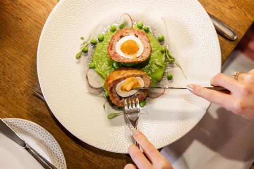 a person eating a plate of food on a table at Greenhills Country Hotel in Saint Peters