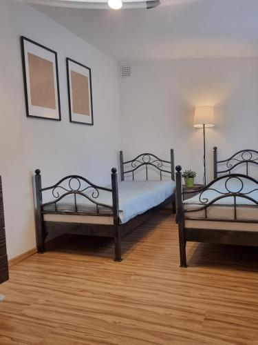 two beds in a room with a wooden floor at DeBoskie Domki in Mrągowo