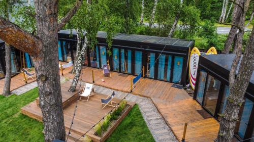 an aerial view of a house with a deck at Klimatyzowane Surf Domki - Maszoperia Sun4Hel - Letnia Baza SnowShow na Półwyspie Helskim in Jastarnia