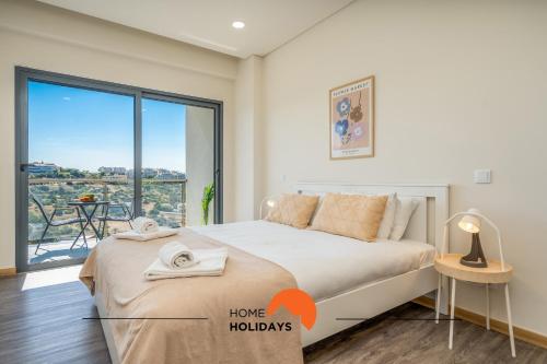 a bedroom with a large bed and a balcony at #233 Fox Trail by Home Holidays in Páteo