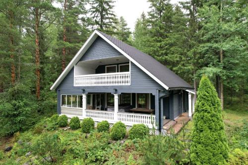 a blue house in the woods with trees at Kerimaa Golf Chalet close to Savonlinna in Savonlinna