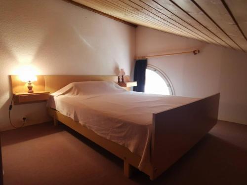 une chambre avec un grand lit et une fenêtre dans l'établissement Appartement familial Duplex La Foux d'Allos au pied du télésiège, à Allos