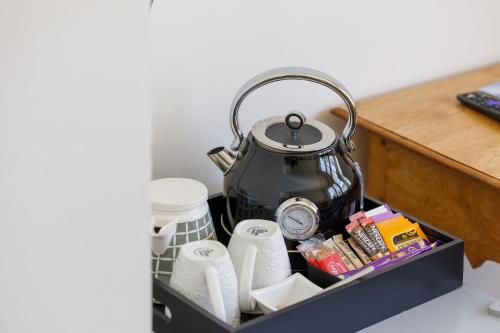 a tea kettle sitting in a tray with toiletries at Finest Retreats - Pittodrie Guest House - Apartment 6 in Brighton & Hove