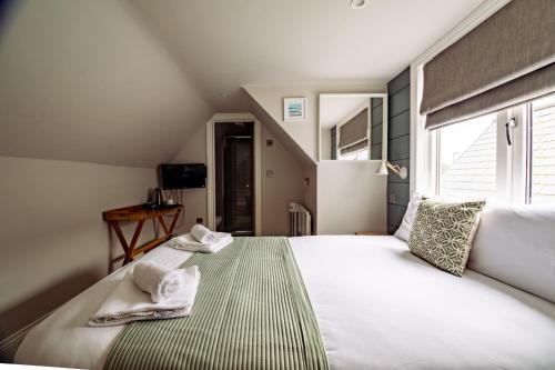 a bedroom with a large bed with towels on it at The Bay Hotel in Pevensey