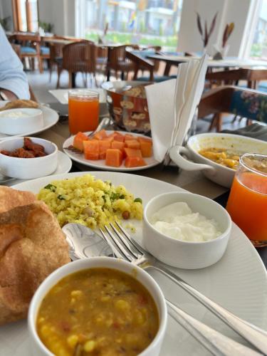 a table with plates of food and bowls of soup at Evara Spa & Resort in Rāmnagar