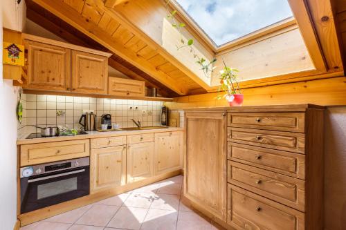d'une cuisine avec des placards en bois et une lucarne. dans l'établissement Village des Oursons Chalet B - Happy Rentals, à Chamonix-Mont-Blanc