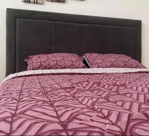 a bed with a purple comforter and pillows at Nkolas in Foča