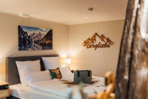 a bedroom with a bed with a mountain sign on the wall at Gasthof Neuhaus in Sassenburg