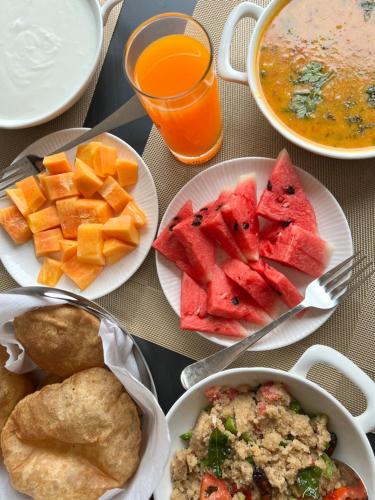 a table with plates of food and a bowl of soup at Evara Spa & Resort in Rāmnagar