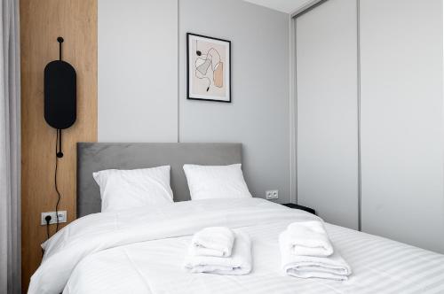 a bedroom with a white bed with towels on it at RentPlanet - Apartamenty Pileckiego in Warsaw