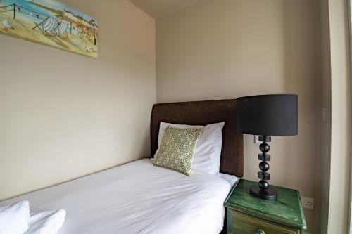 a bedroom with a bed with a lamp on a night stand at The Bay Hotel in Pevensey