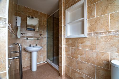 a bathroom with a sink and a shower at The Bay Hotel in Pevensey