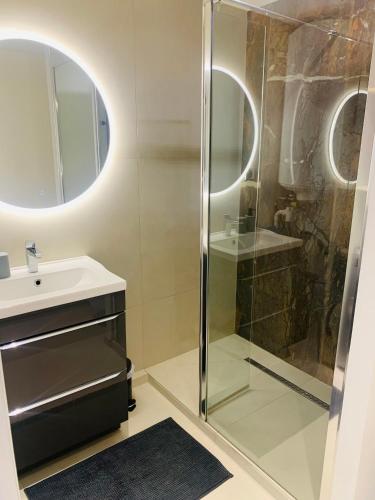 une salle de bain avec une douche en verre et un lavabo dans l'établissement Location T2, à Fréjus