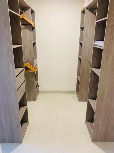 un dressing avec des armoires en bois et un sol blanc dans l'établissement Location T2, à Fréjus