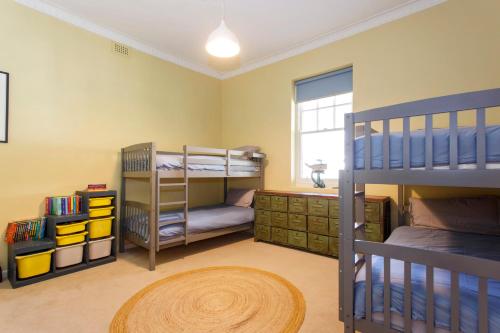 ein Schlafzimmer mit zwei Etagenbetten und einem Fenster in der Unterkunft Lillys Cottage Heritage House South Fremantle in South Fremantle