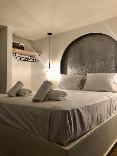 a bedroom with a large bed with a large headboard at LefkoParga Luxury Suites in Parga