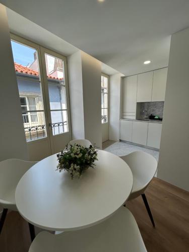 a white dining room with a white table and chairs at Crato Apartments in Viana do Castelo