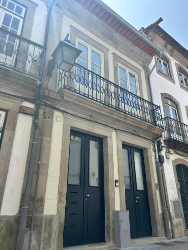 a building with a blue door and a balcony at Crato Apartments in Viana do Castelo