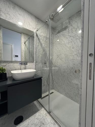 a bathroom with a sink and a glass shower at Crato Apartments in Viana do Castelo