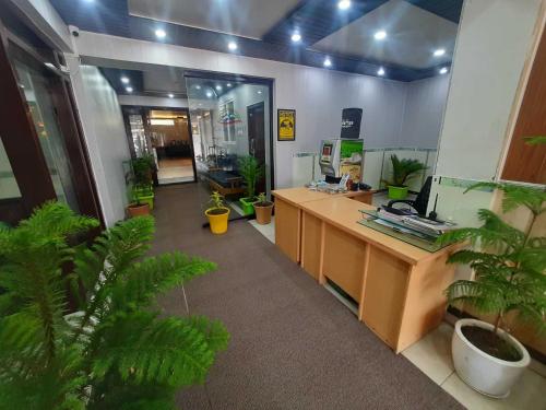 an office with a desk and potted plants at Hotel O Graceland in Srīnagar