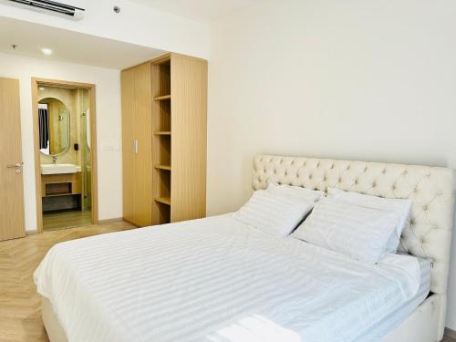 a bedroom with a white bed with white sheets and pillows at Masteri - Vinhome Grand Park - HELEN APARTMENT in Ho Chi Minh City