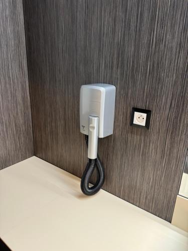 a white phone on a wall with a black cord at New York Pension in Dunajská Streda