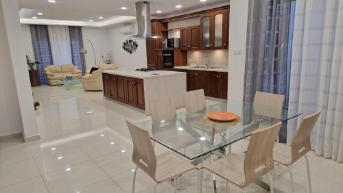a kitchen and dining room with a glass table and chairs at Carousel Apartments in Qrendi