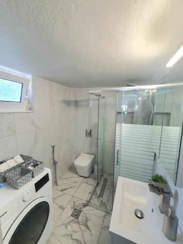 a bathroom with a sink and a toilet and a shower at Riviera Penthouse in Paleo Tsifliki