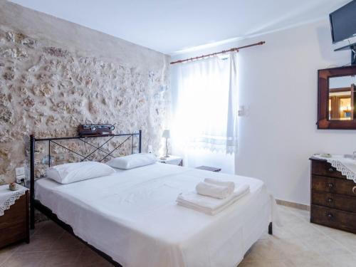a bedroom with a white bed with towels on it at Olga's Home Oitylo in Oítilon
