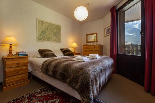 une chambre avec un grand lit et une fenêtre dans l'établissement Appartement Lachenal 209A - Happy Rentals, à Chamonix-Mont-Blanc