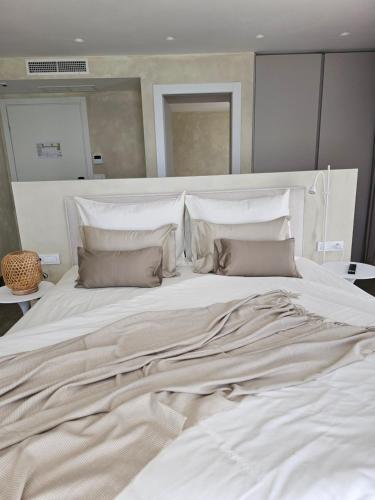 a large bed with white sheets and pillows at Hotel Aria in Podstrana