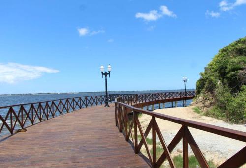 a wooden bridge over the water on the beach at Apartamento em frente a lagoa de Araruama in Araruama