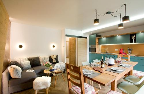 un salon avec une table et un canapé dans l'établissement La plus belle vue des 2 Alpes !, à Les Deux Alpes