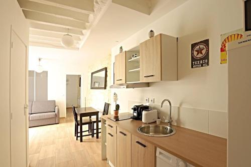 - une cuisine avec un évier et une table dans une chambre dans l'établissement Appart Faubourg St Denis 4 personnes, à Paris