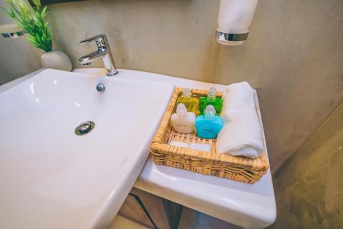a bathroom sink with a basket with detergents on it at Villa Sewinro in Talpe