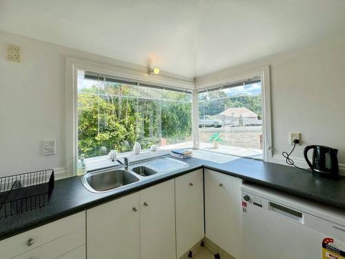 a kitchen with a sink and a large window at Harbourview Khandallah Charm in Wellington