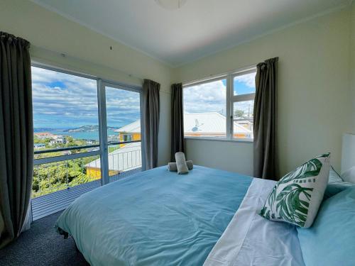 a bedroom with a large bed and a large window at Harbourview Khandallah Charm in Wellington