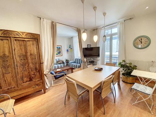 un salon avec une table et des chaises en bois dans l'établissement en centre ville magnifique pied a terre ran44, à Cannes