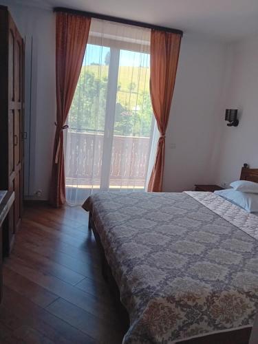 una camera da letto con un letto e una grande finestra di Pensiunea Delia a Vatra Moldoviţei