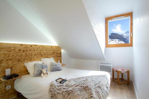 une chambre avec un lit avec un ours en peluche dessus dans l'établissement La plus belle vue des 2 Alpes !, à Les Deux Alpes