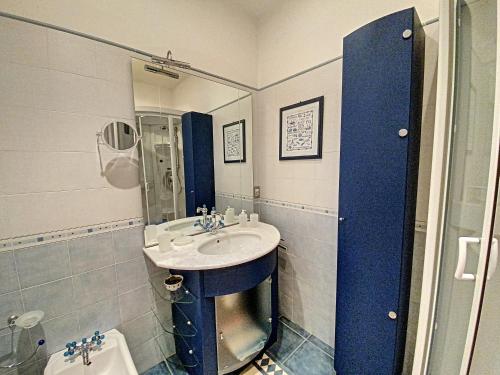 La salle de bains bleue et blanche est pourvue d'un lavabo et d'une douche. dans l'établissement en centre ville magnifique pied a terre ran44, à Cannes