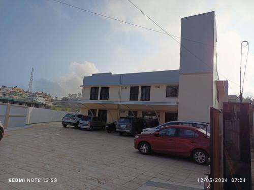 un parcheggio con auto parcheggiate davanti a un edificio di Arasan Residency a Kotagiri