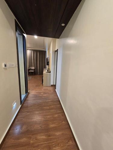 a hallway with white walls and a wooden floor at Mastiff Select Medha Plaza Deoghar in Deoghar