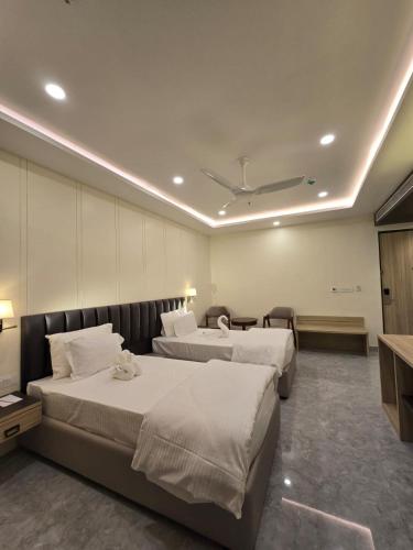 a hotel room with two beds and a television at Mastiff Select Medha Plaza Deoghar in Deoghar