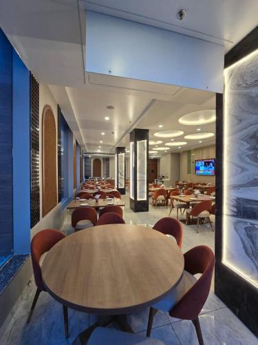 a cafeteria with tables and chairs in a building at Mastiff Select Medha Plaza Deoghar in Deoghar