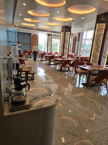 a restaurant with tables and chairs and people walking around at Mastiff Select Medha Plaza Deoghar in Deoghar