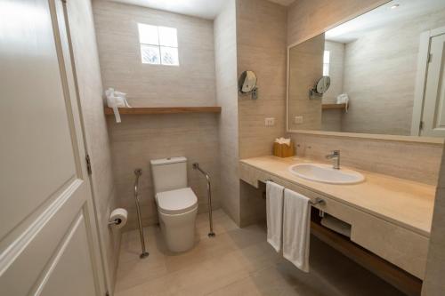 a bathroom with a toilet and a sink and a mirror at Iberostar Selection Hacienda Dominicus - All Inclusive in Bayahibe