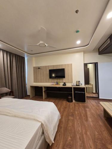a hotel room with a bed and a flat screen tv at Mastiff Select Medha Plaza Deoghar in Deoghar
